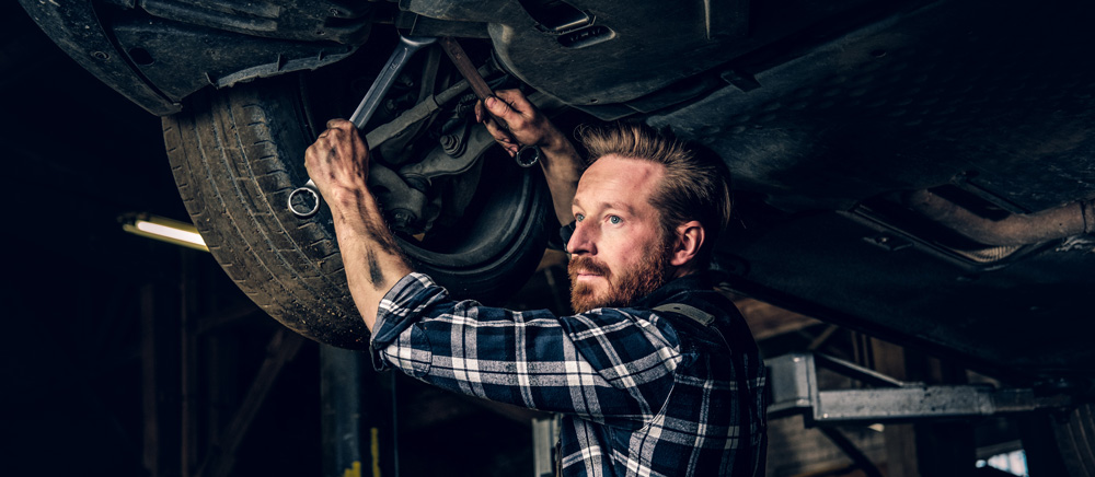 Image of auto mechanic adjusting suspension